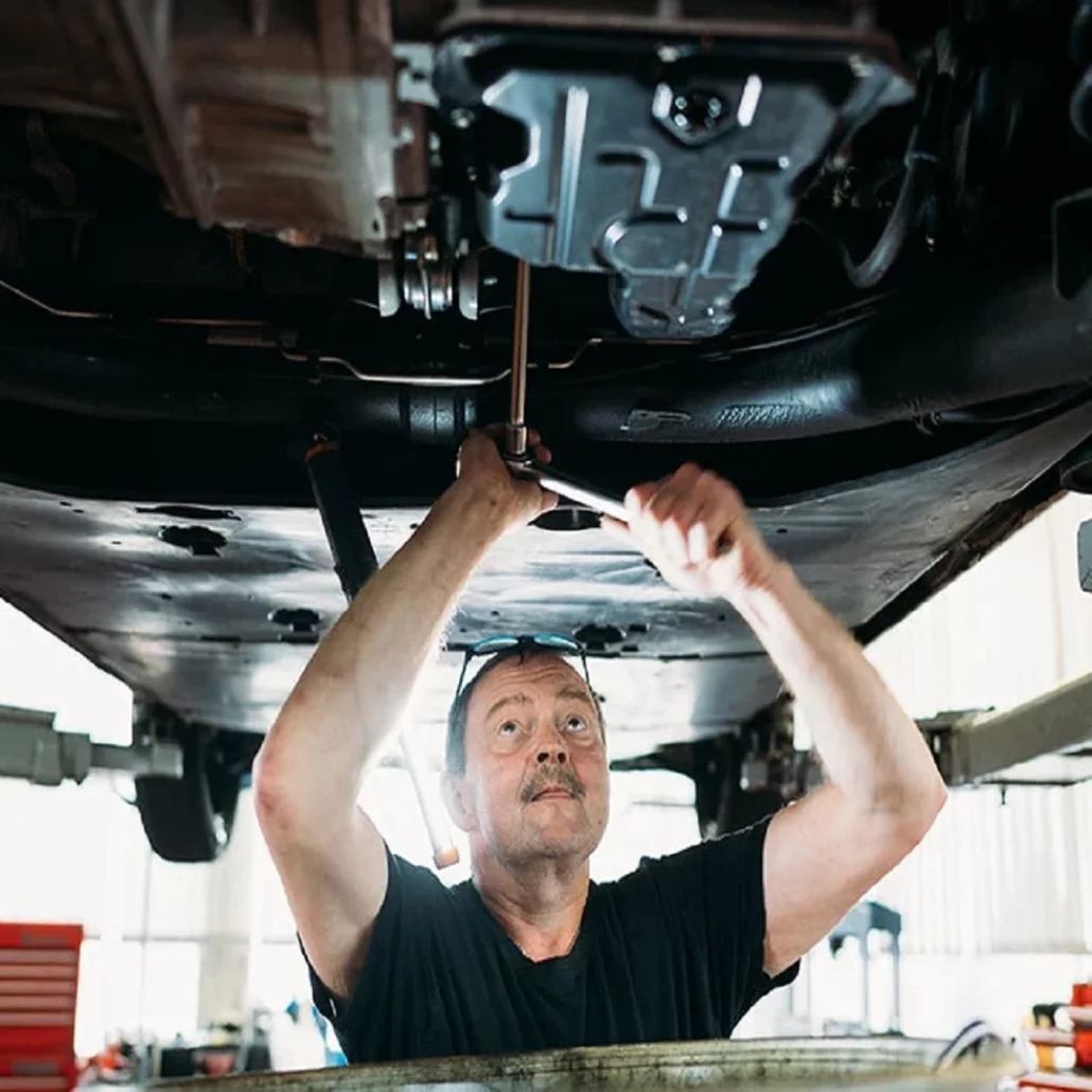 Ein Mann arbeit am Auto in einer Werkstatt